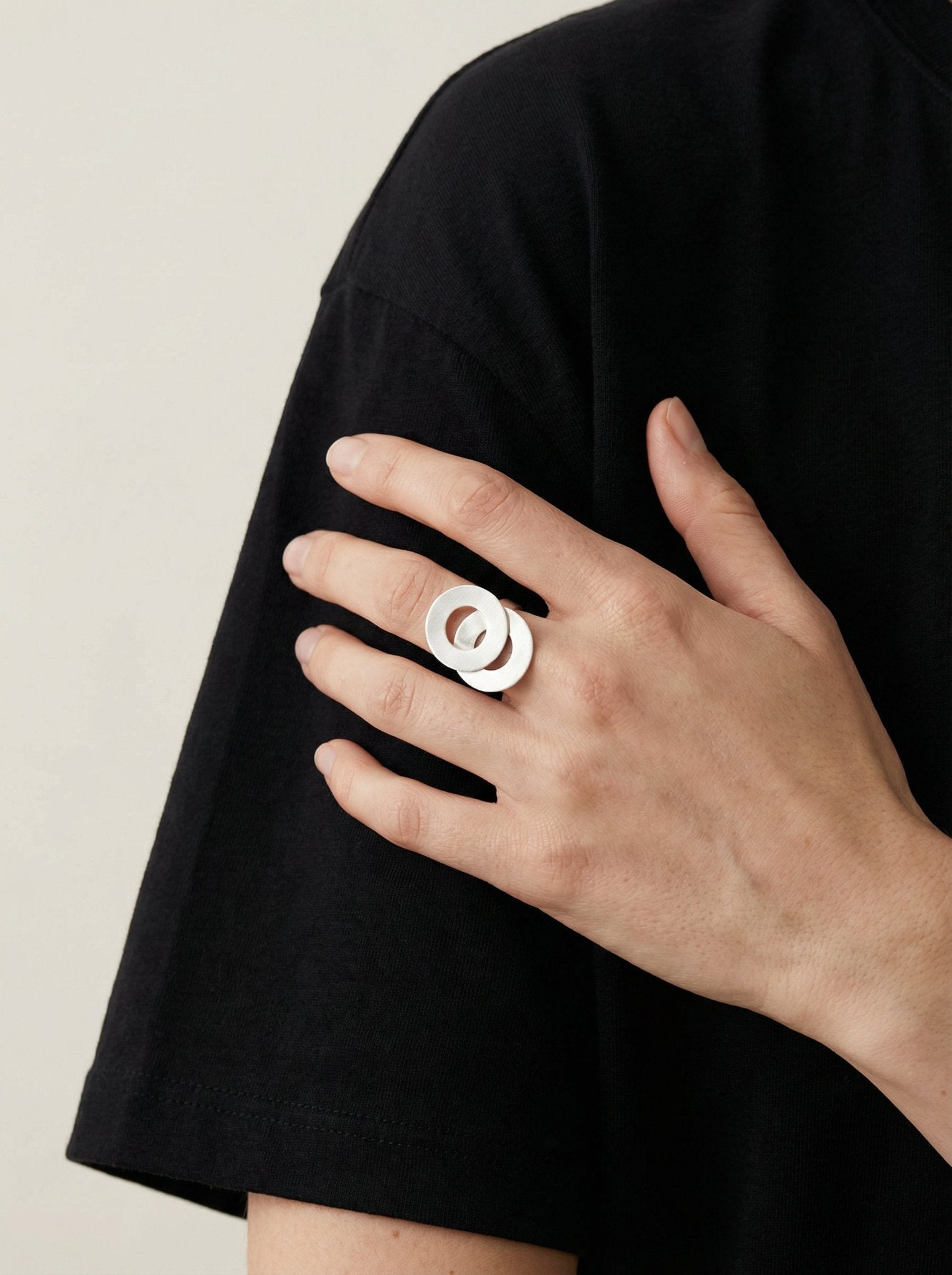 Silver ring two interlaced infinity symbol circles. Statement jewelry handcrafted in Brooklyn New York by designer llayers.