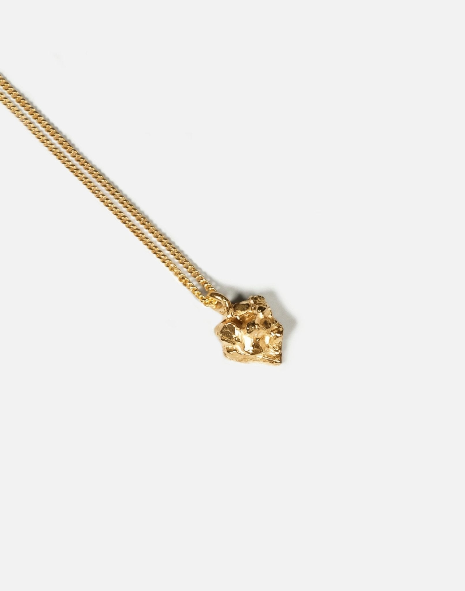 gold minimalist rock pendant necklace in new york by llayers 
