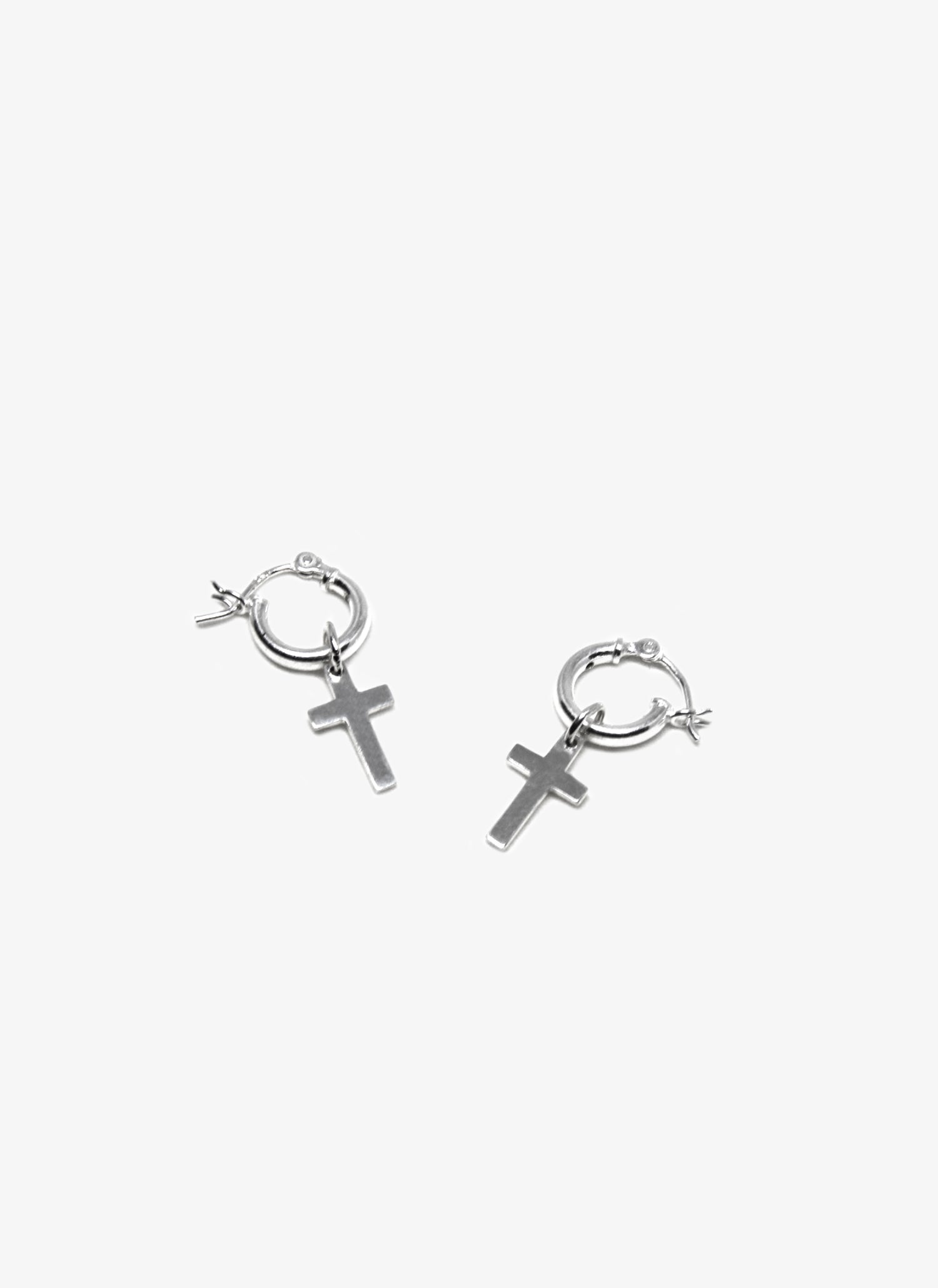 Silver hoop earrings with cross charms on a white background
